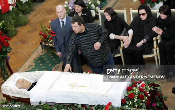 Man touches a coffin as Galina Vishnevskaya , the widow and daughters Yelena and Olga sit near the coffin of Mstislav Rostropovich, the legendary...