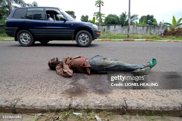 Car drives past a dead body lying on a street, 24 March 2007, in Kinshasa. Calm has returned to the city centre while police and United Nations...