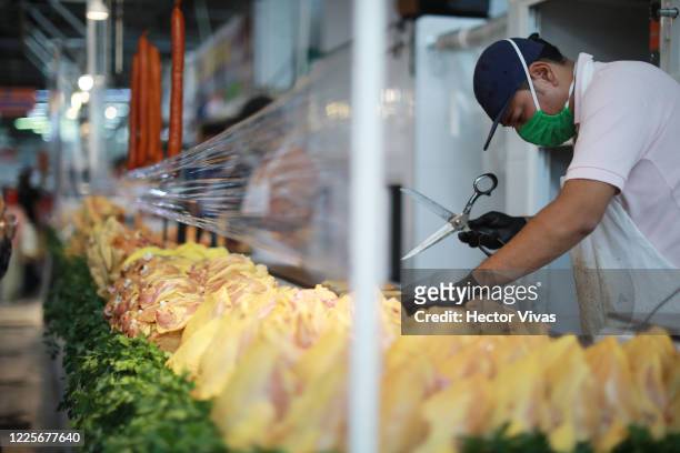 Chicken vendor works at Martínez de la Torre market on May 18, 2020 in Mexico City, Mexico. After three weeks of being closed due to positive of...