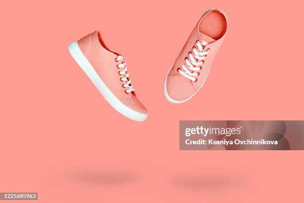 white sneakers with purple laces on yellow background. modern minimal fashion art trendy bold color still life - white shoe fotografías e imágenes de stock