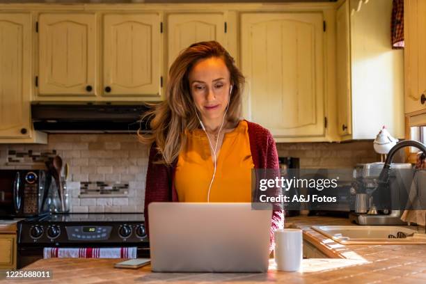 femme travaillant de la maison. - ornement auriculaire photos et images de collection