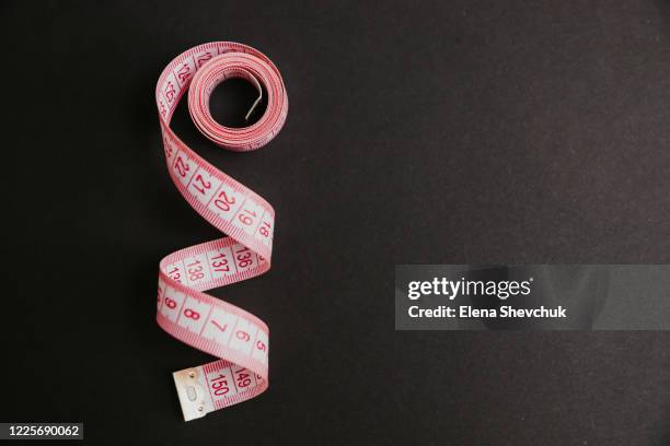 tape measure isolated on black background - mètre à ruban photos et images de collection