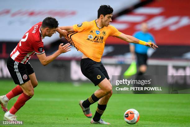 Sheffield United's Irish defender John Egan vies with Wolverhampton Wanderers' Mexican striker Raul Jimenez during the English Premier League...