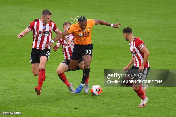 Wolverhampton Wanderers' Spanish midfielder Adama Traore vies with Sheffield United's English defender Jack O'Connell and Sheffield United's English...