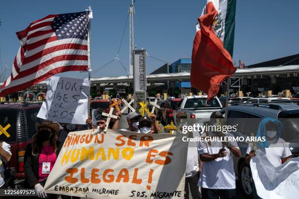 Members of migrant advocate groups demonstrate against US President Donald Trump's migration policies with US and Mexican flags, crosses and a sign...