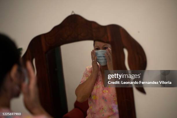 Nurse Rosaura Rodriguez puts on a medical mask before leaving to work at the health center on the other side of the city during week 17 of strict...