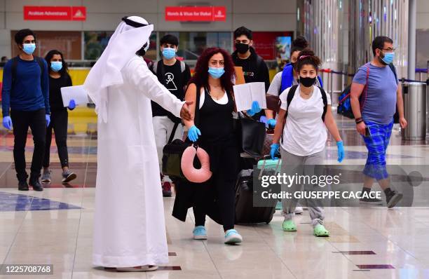 Tourists arrive at Dubai airport in the United Arab Emirates on July 8 as the country reopened its doors to international visitors in the hope of...