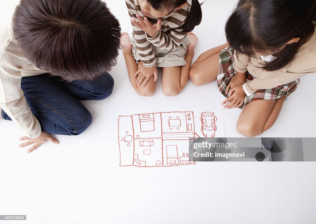 Mother and children looking at a pictuere of room layout