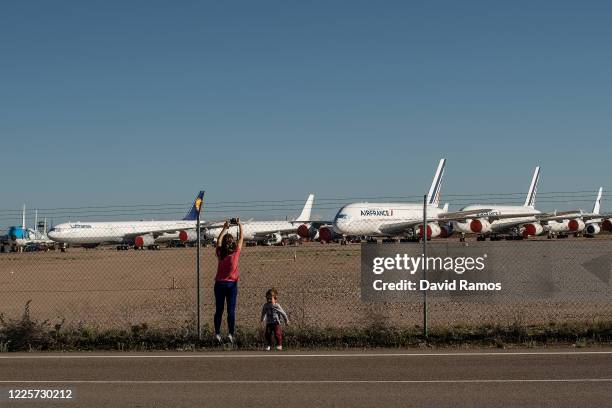 Marta Garcia takes pictures to Airbus A380 operated by Air France and A340 operated by Lufthansa aircraft parked at Teruel Airport next to her son...