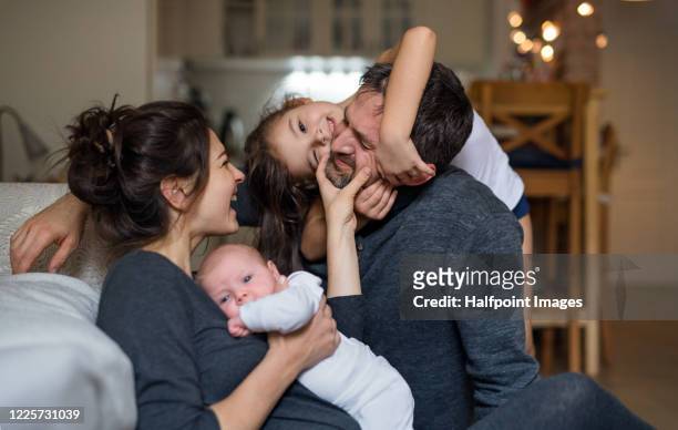 father, mother with small daughter and newborn baby indoors at home, having fun. - newborn sibling stock pictures, royalty-free photos & images