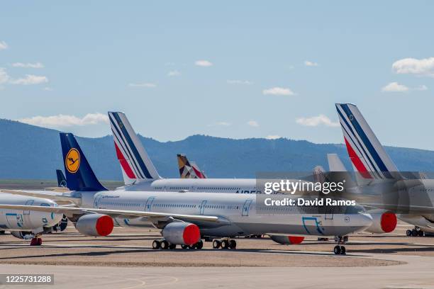 An Airbus A340 passenger aircraft operated by Lufthansa stand next to Air France aircraft parked in a storage facility operated by TARMAC Aerosave at...