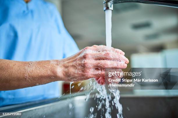 doctor washing hands - doctor scrubs stock pictures, royalty-free photos & images