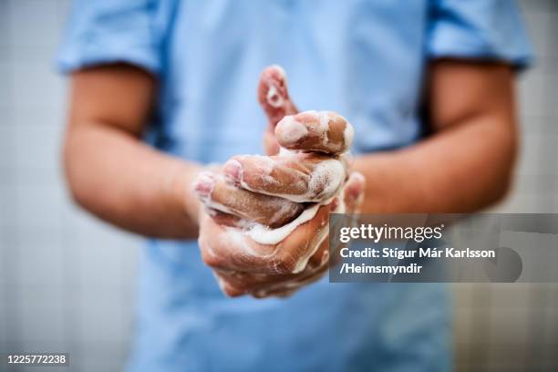 mannelijke gezondheidszorgarbeider die handen wast - hygiëne stockfoto's en -beelden