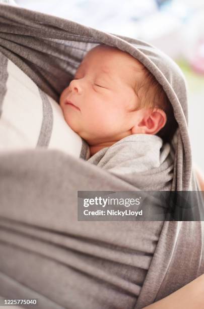 das baby ist immer in der nähe ihrer mutter - babytrage stock-fotos und bilder