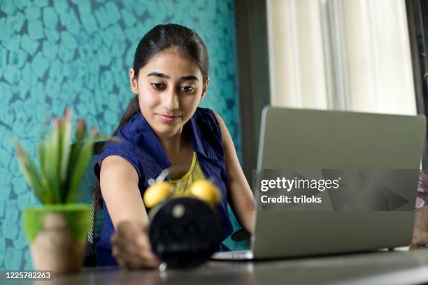 girl checking time by laptop at home - quiz time stock pictures, royalty-free photos & images