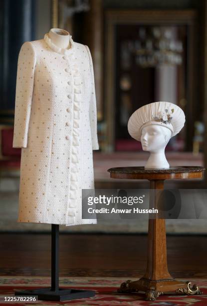 The ivory dress and coat, in white Boucle fabric and threaded throughout with silk ribbon, designed by Miss Angela Kelly MVO, which Queen Elizabeth...