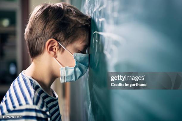 weinig jongen die door school tijdens covid-19 pandemie wordt gedeprimeerd. - nederlaag stockfoto's en -beelden