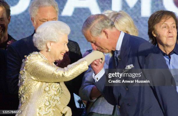 Watched by music celebrities, Prince Charles, Prince of Wales kisses the hand of his Mother Queen Elizabeth ll during The Diamond Jubilee Concert in...