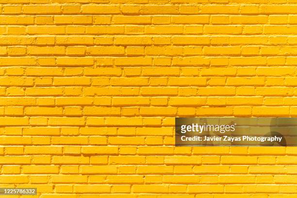 yellow brick wall background - yellow stock-fotos und bilder