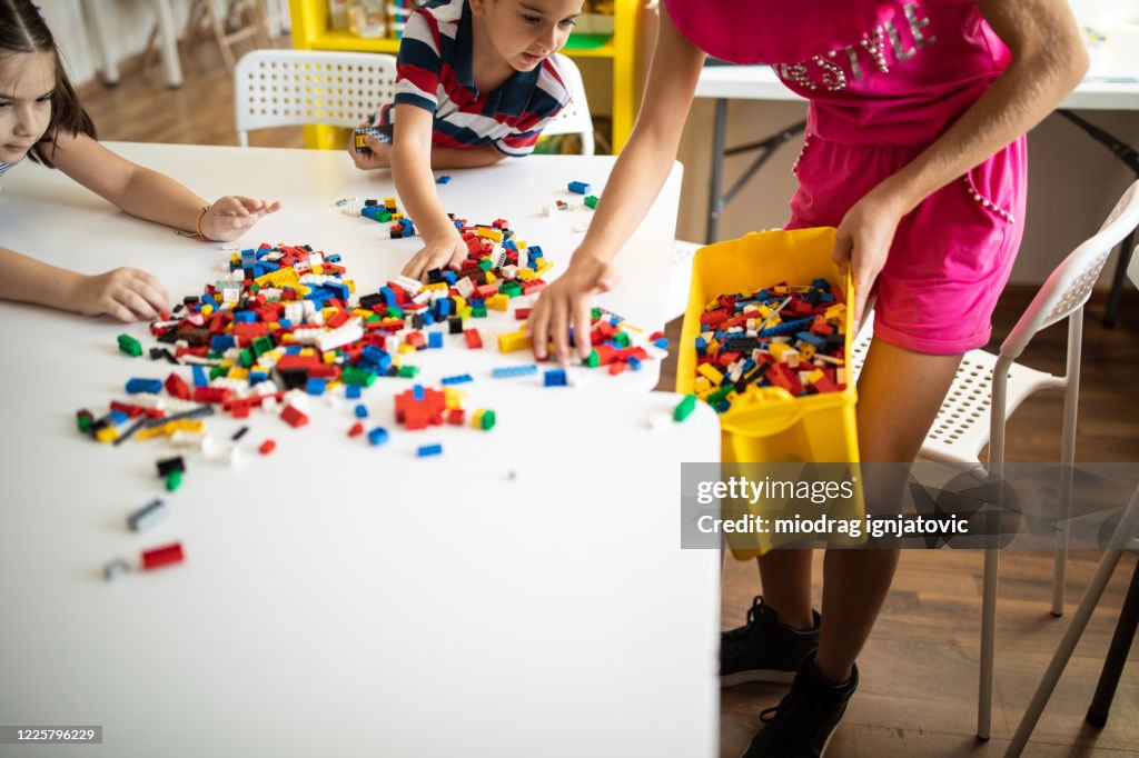 Children collecting toys after play time at childcare