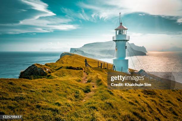 lighthouse on a cliff - faroe islands stockfoto's en -beelden