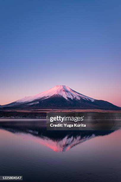 pink fujiyama reflected in lake yamanaka in the morning - yamanaka lake stockfoto's en -beelden