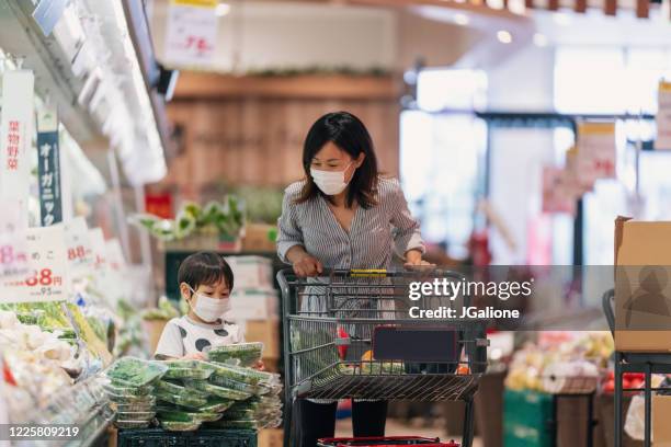 フェイスマスクを着用した母と息子がスーパーマーケットで一緒に買い物をする - スーパーマーケット　日本 ストックフォトと画像