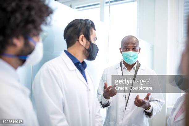 multiethnic group of doctors at the hospital. - group of people with masks stock pictures, royalty-free photos & images
