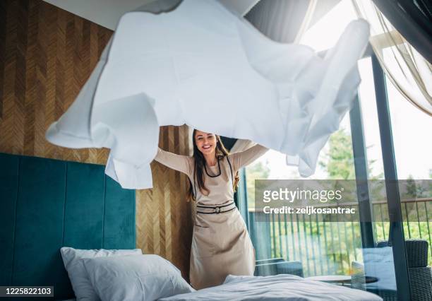 huishoudster die het bed in een hotel maakt - hospitality worker stockfoto's en -beelden
