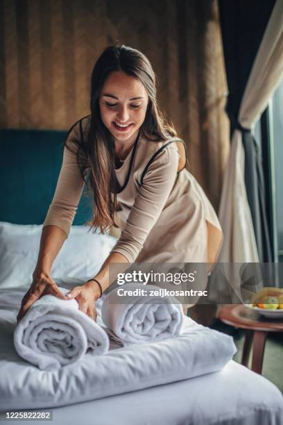 governante che fa il letto in un hotel - servizio in camera foto e immagini stock