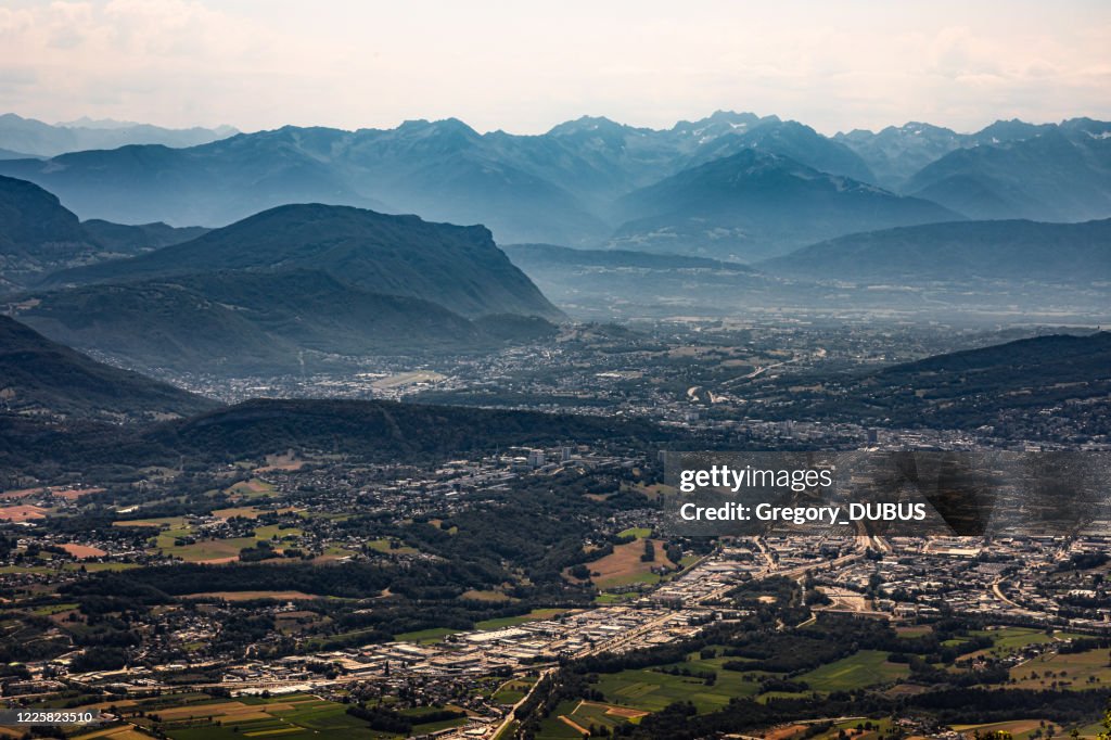 Aerial view on the French city of Chambery and its surroundings at dusk with mist between the Alps mountains