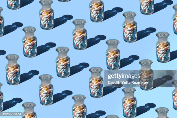 bottles full of various pills and tablets on the blue background - kopiera bildbanksfoton och bilder