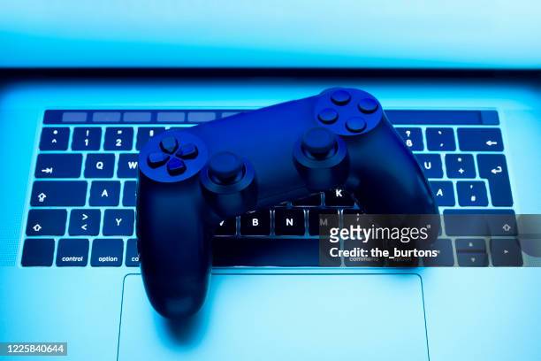 high angle view of game controller on laptop - sportliga stock-fotos und bilder