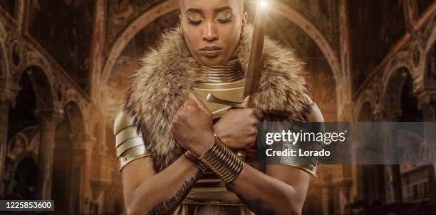 golden viking inspired warrior female in studio shot - wakanda forever pose stock pictures, royalty-free photos & images