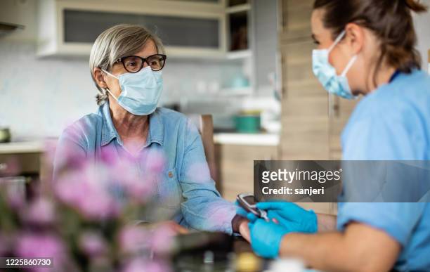 district nurse at home visit - covid visit stock pictures, royalty-free photos & images