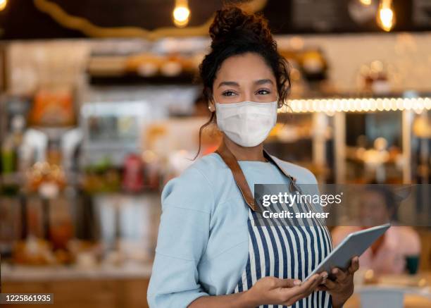 beautiful waitress working at a restaurant wearing a facemask - restaurant corona stock pictures, royalty-free photos & images