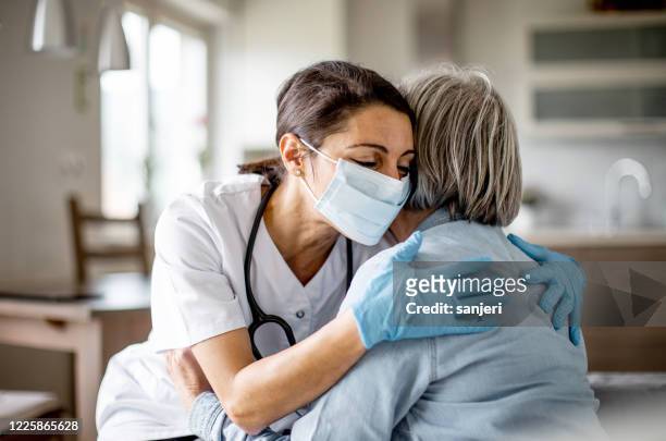 operatore sanitario a casa visita - abbracciare una persona foto e immagini stock