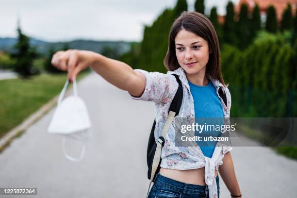 young woman taking off face mask - end of life care stock pictures, royalty-free photos & images