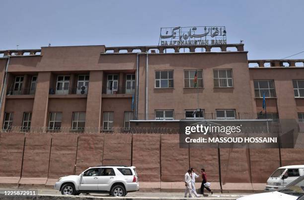 Afghan men walk past Da Afghanistan Bank in Kabul on June 28, 2011. Afghanistan's central bank governor has resigned and fled to the United States,...