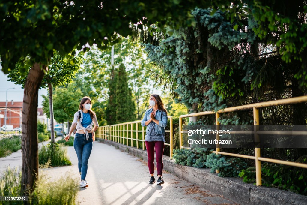 Dos amigos sosteniendo la distancia social durante la caminata