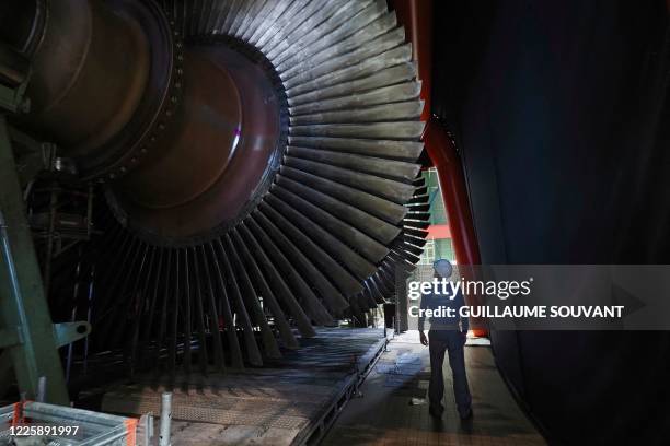 Worker stands by the rotor turbine which is being repaire on-site, in the engine room of the nuclear power plant of Chinon in Avoine, central France...