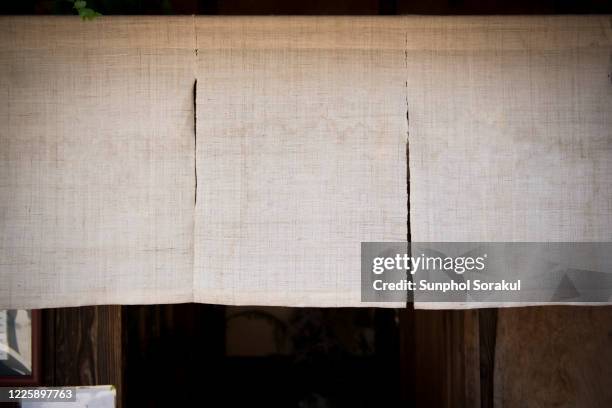 a linen noren japanese curtain still a doorway from street - noren stock pictures, royalty-free photos & images