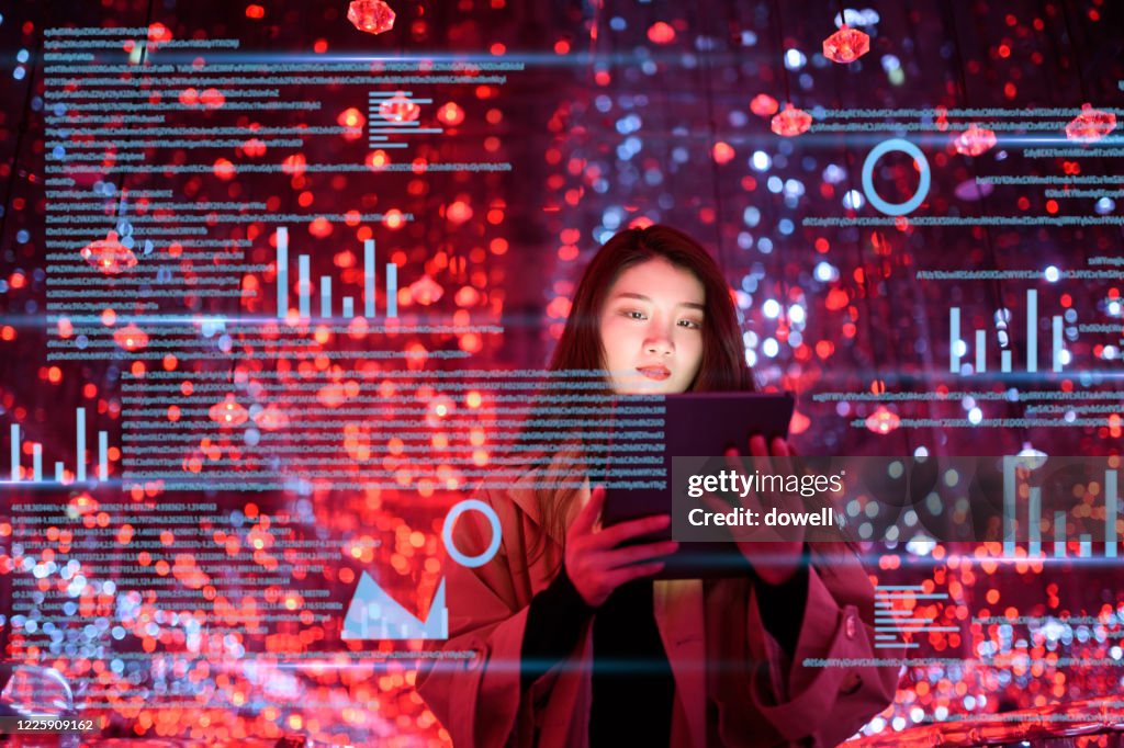 Young woman uses digital tablet on virtual visual screen at night