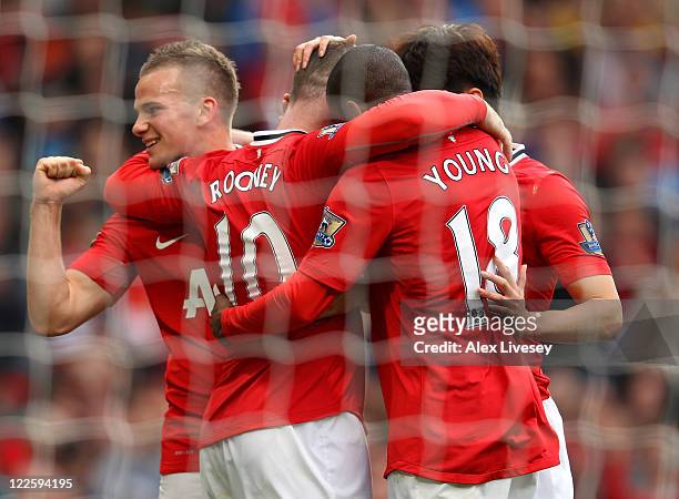 Wayne Rooney of Manchester United celebrates Tom Cleverley and Ashley Young after scoring his third goal from the penalty spot during the Barclays...