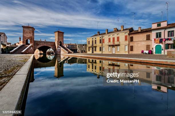 view of the trepponti bridge and canal in comacchio, italy - ferrara stock pictures, royalty-free photos & images