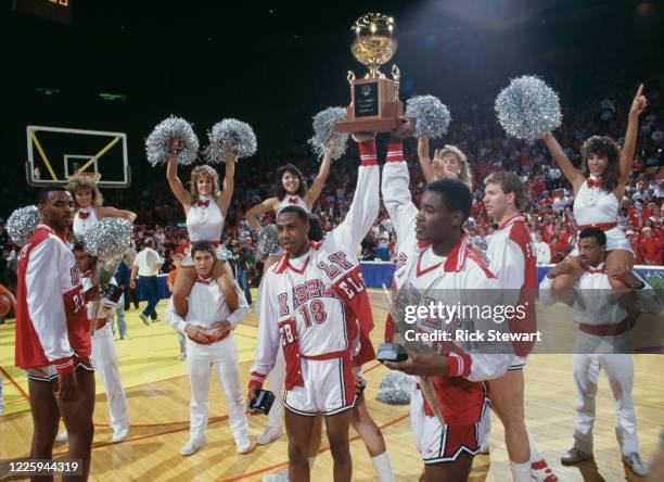 Freddie Banks and Gary Graham, Guards for the University of Las Vegas Nevada Rebels hold the trophy aloft and celebrate with their team after winning...