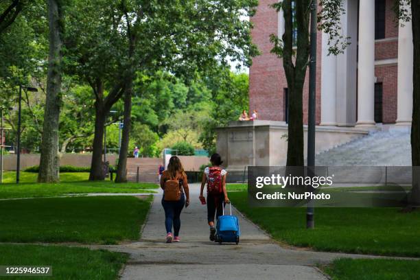 Two students are seen leaving their campus with baggage at Harvard University premises in Cambridge, MA, July 08, 2020.