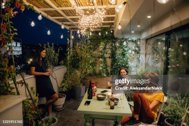 freundinnen genießen wein auf der offenen terrasse - building terrace stock-fotos und bilder