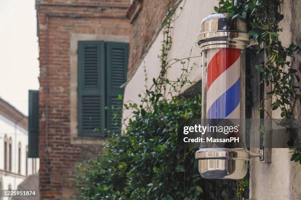 barber's pole on a street in ferrara, old style editing - barber pole stock pictures, royalty-free photos & images