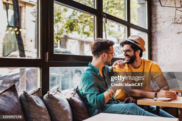 dos hombres en un bar después del trabajo - hombre gay fotografías e imágenes de stock